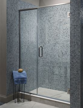 Glass-enclosed shower with small blue-gray tiles on wall.