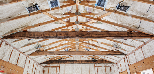 Spray foam insulation installed in the ceiling of a building under construction.