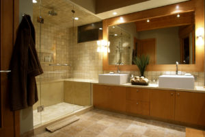 Updated bathroom with glass-enclosed shower, recessed lighting, and dual vanity.