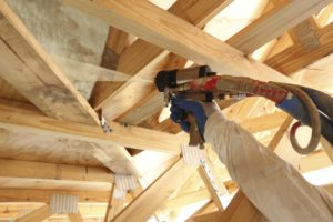 Spray foam insulation being installed via spray gun into a ceiling by IBP of Tampa.